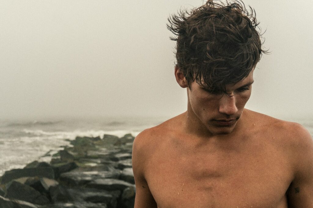 man looking down at beach