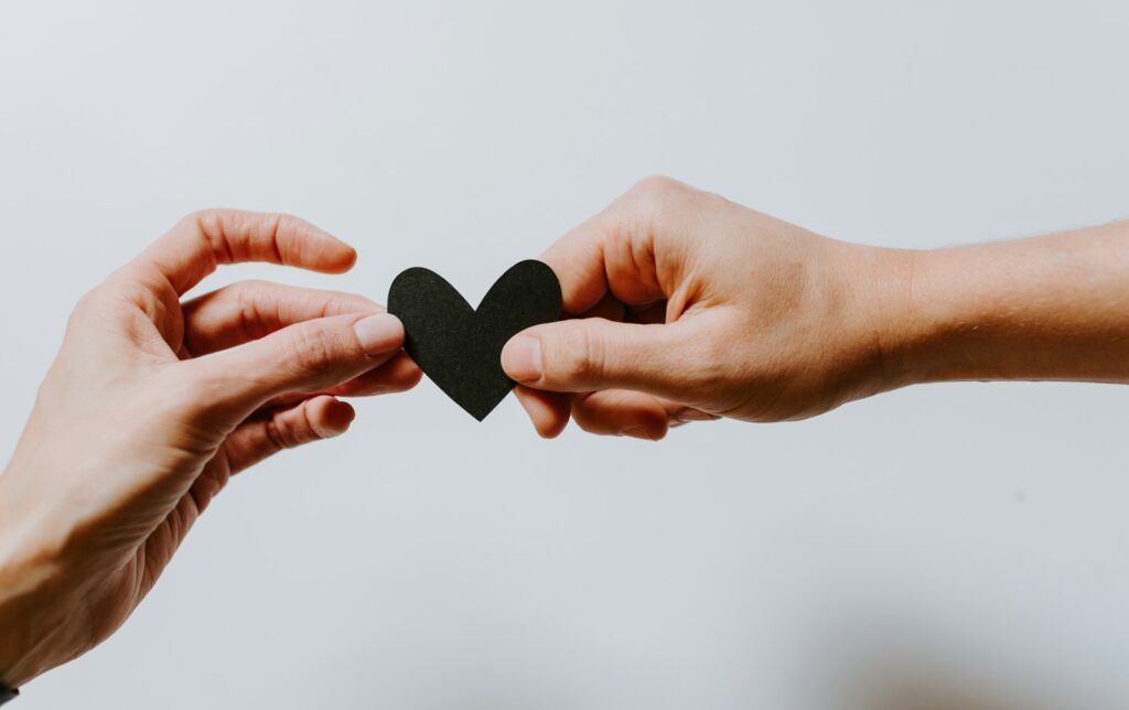 black heart connected between 2 hands