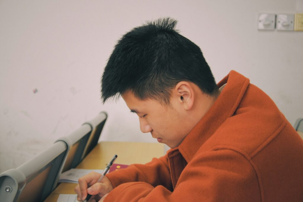 Evaluating man writing on pad