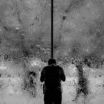 man stood next to a black wall