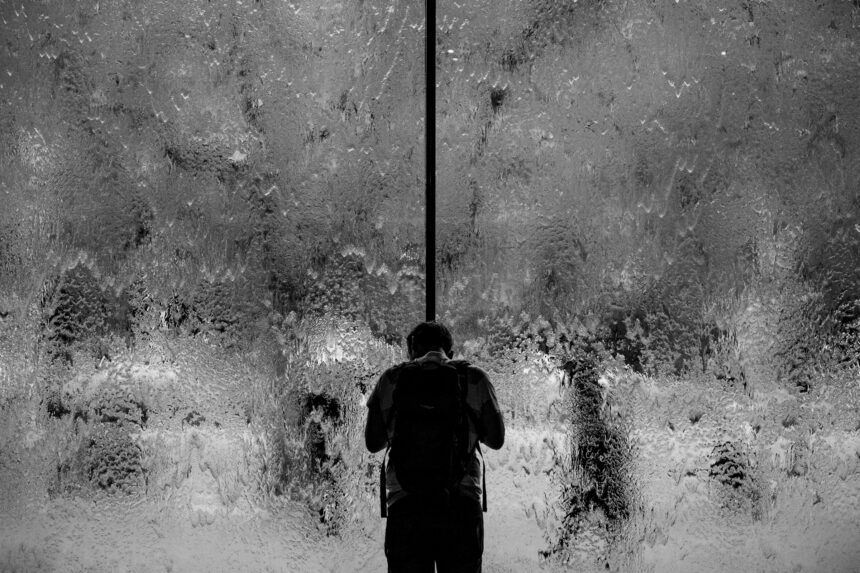 man stood next to a black wall