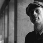 man with flat cap in alley