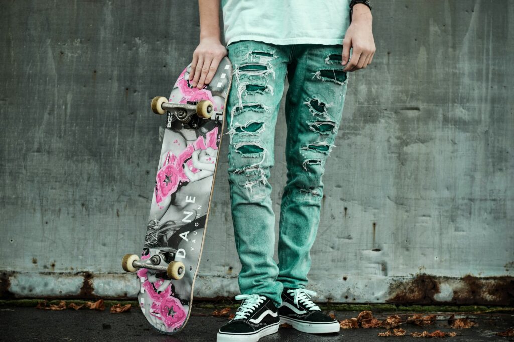 man in ripped jeans with scateboard